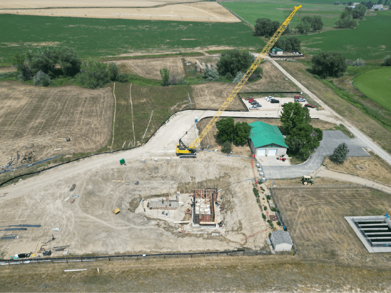 Aerial view of a construction site featuring a crane, showcasing the development of Niwot Sanitation's new Headworks building.