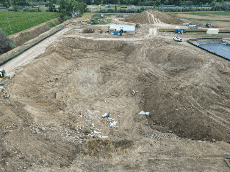 Elevated view of a construction site with dirt and equipment, highlighting the cleared area for the upcoming oxidation ditch.