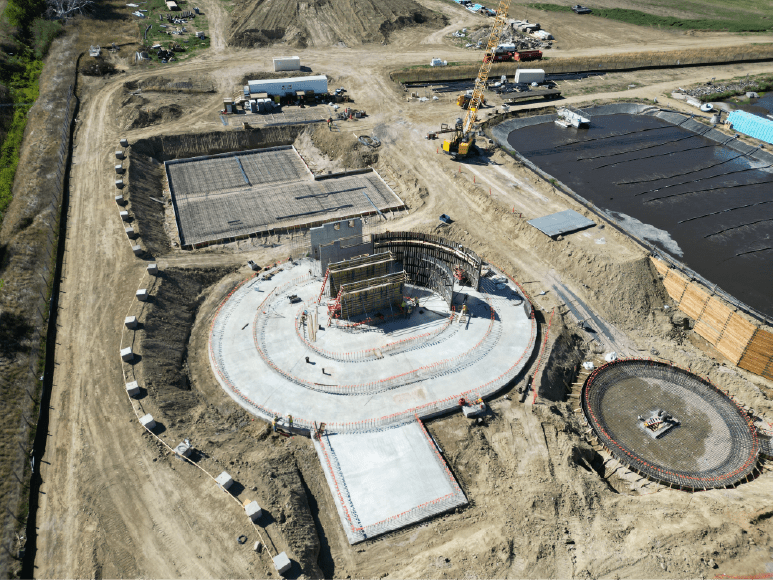 Aerial view of a construction site featuring a large water tank and oxidation ditch designed for wastewater treatment processes.