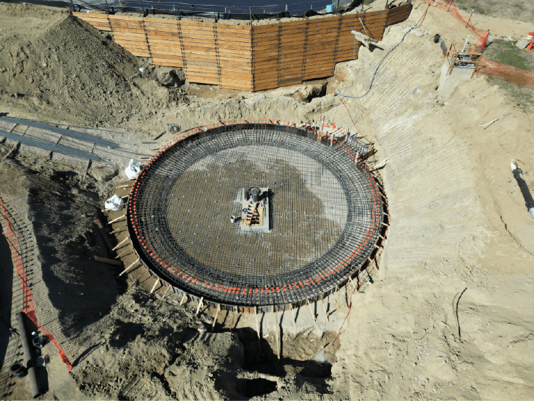 Aerial view of a circular concrete structure, showcasing completed rebar for the secondary clarifier's slab, ready for cement pour.