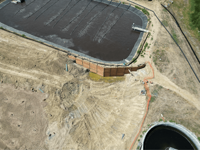 Aerial view of a large water treatment plant with shoring around the basin for safe excavation of the secondary clarifier.